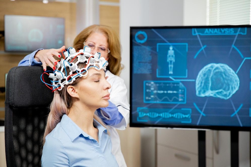 Woman undergoing a brain scan with electrodes attached to her head