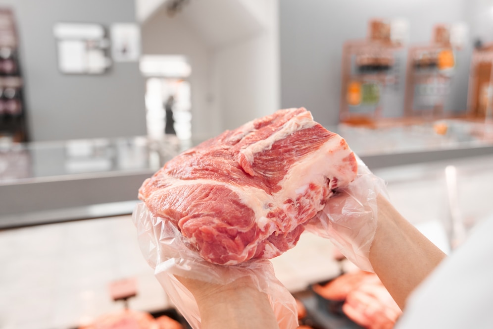 Person holding a raw, marbled meat