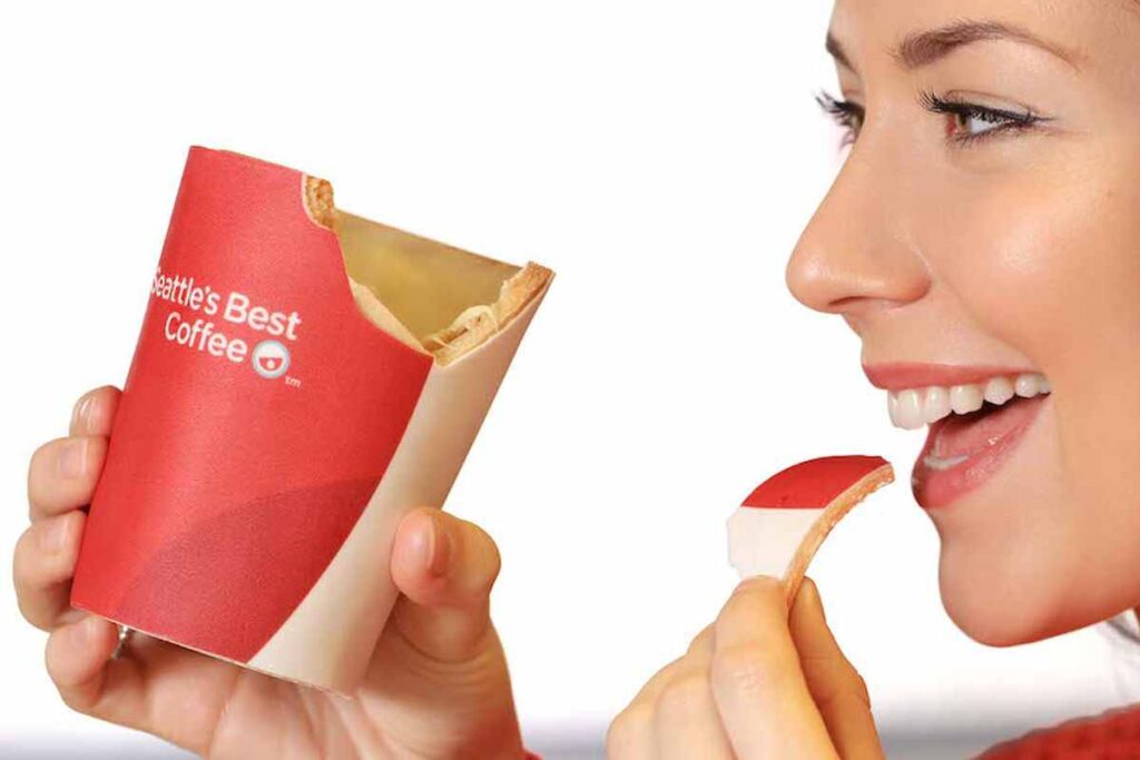 Woman smiling while eating a piece of cheese from a branded package