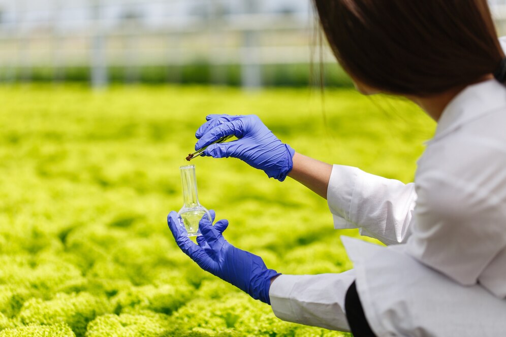Scientist in lab coat and gloves conducting experiment