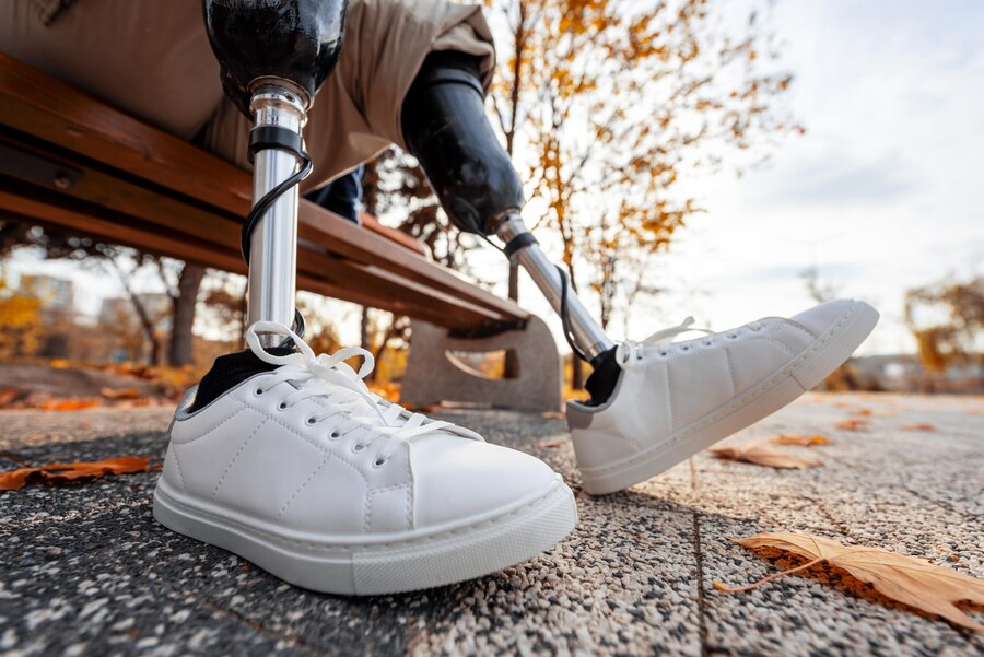 Close-up of a person with a prosthetic leg wearing white sneakers