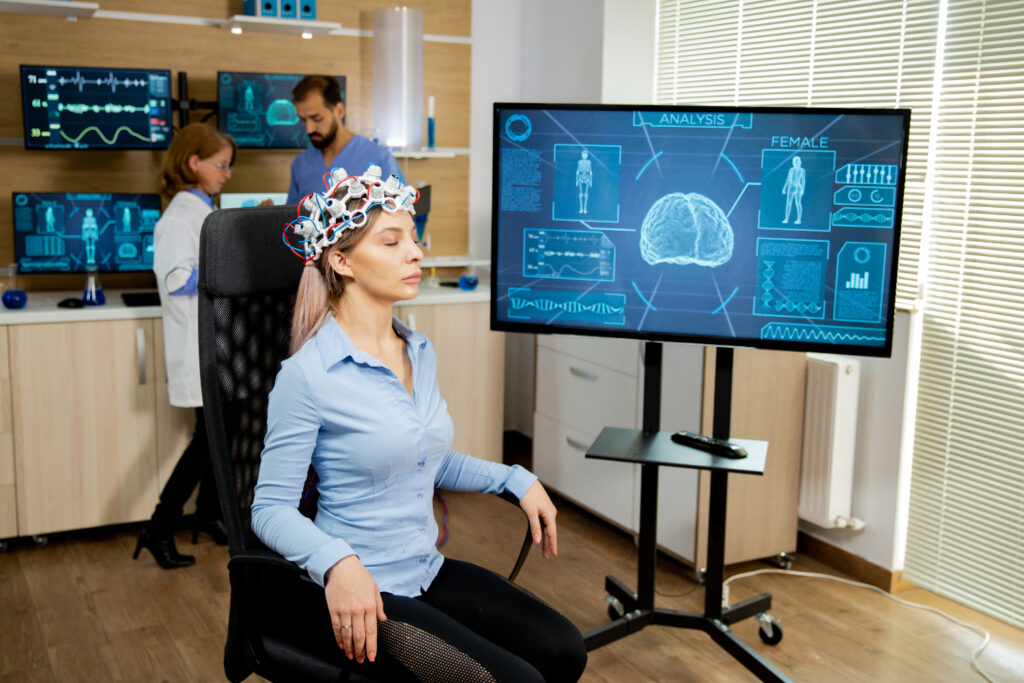 Woman wearing a brainwave scanning device sits in a lab