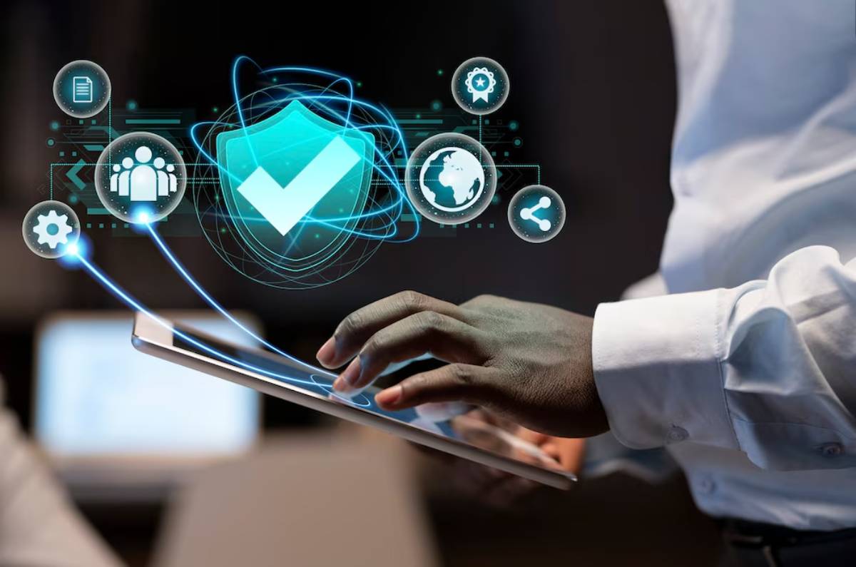 Person using a tablet with futuristic cybersecurity and technology icons floating above the screen.
