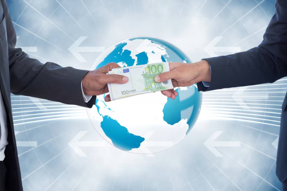 Two businessmen exchanging 100 Euro banknote over a globe, symbolizing global finance or international transaction.